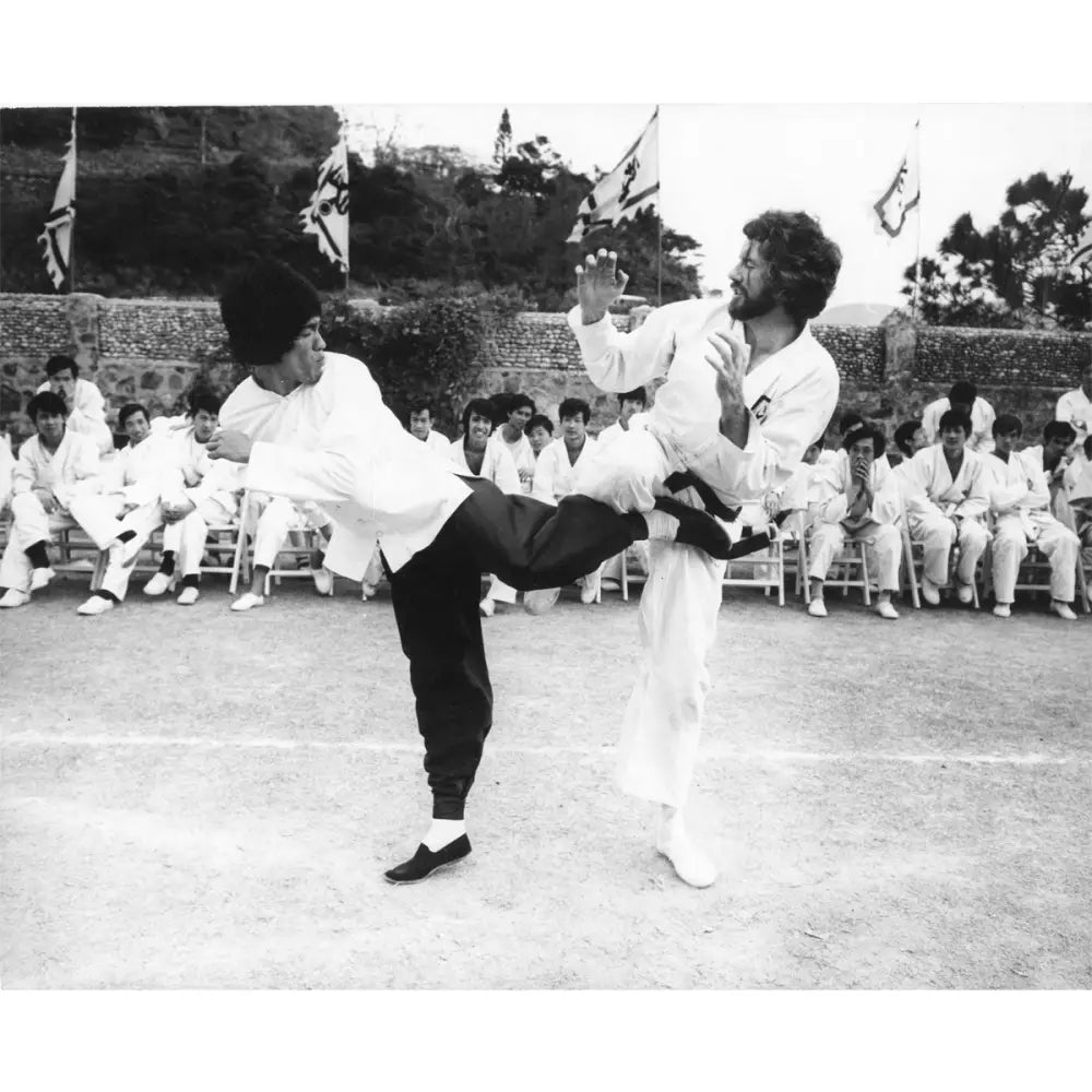 Two martial artists sparring, showcasing Bruce Lee’s uniform and legendary kick
