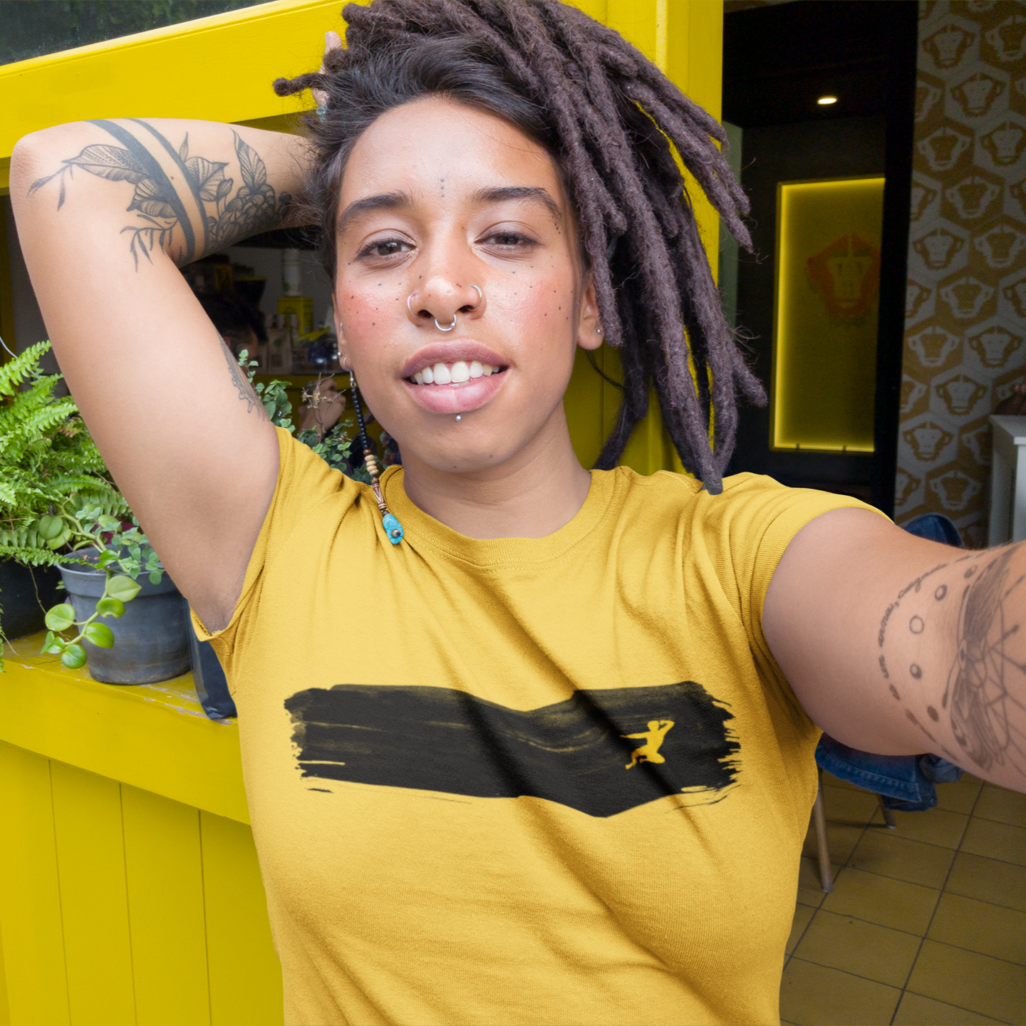 Smiling person with dreadlocks in Black Brushstroke T-Shirt - Gold showcasing style